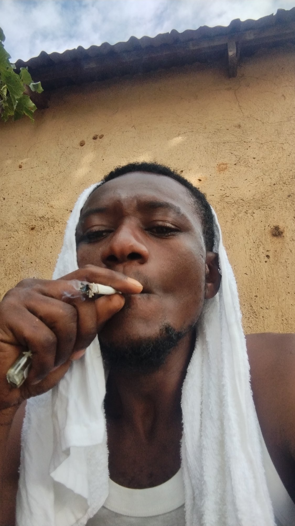 Casual outdoor selfie session in Jos, towel and cigarette in hand