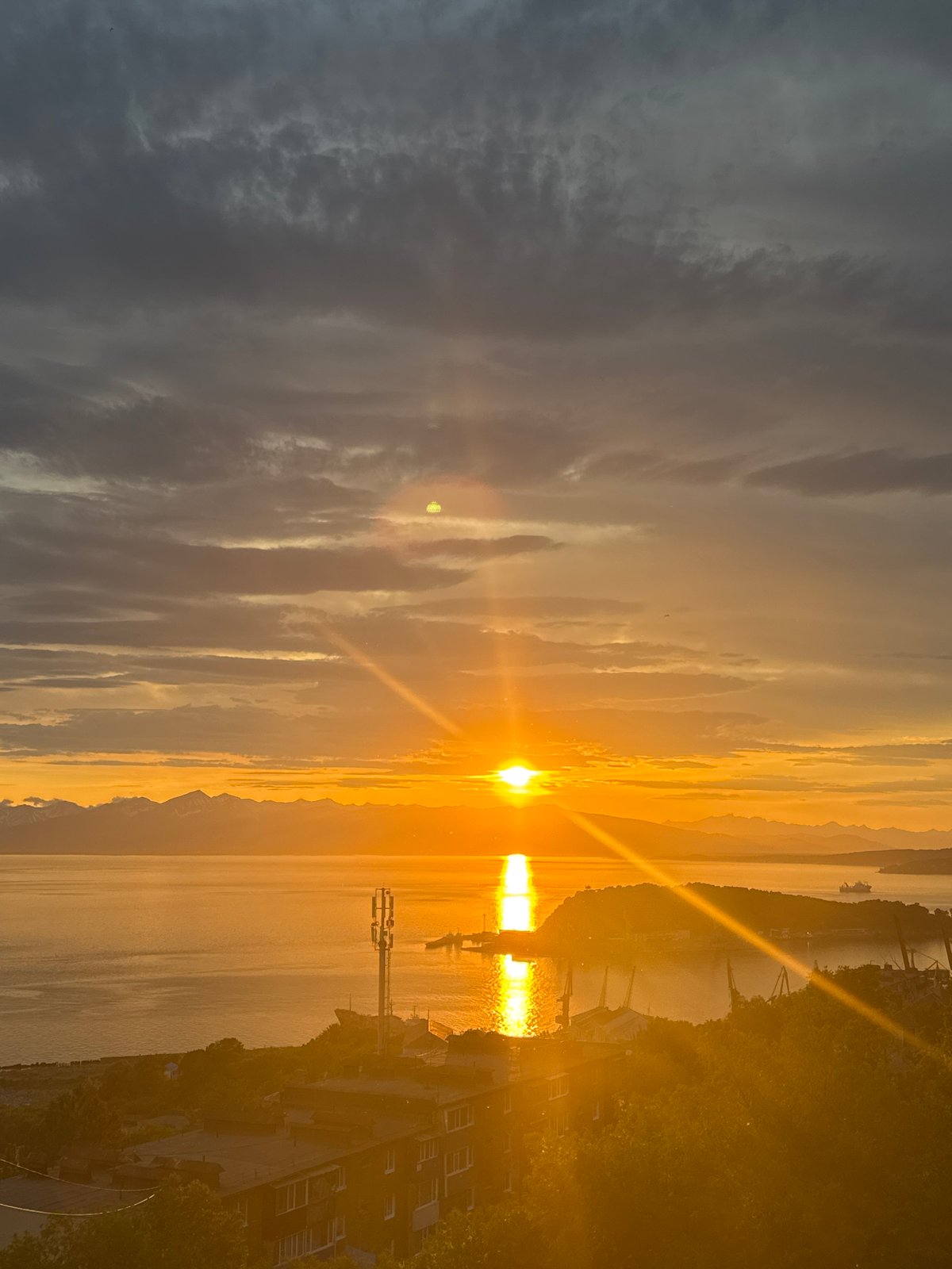 Fiery sunset over mountain-rimmed Pacific waters, Kamchatka