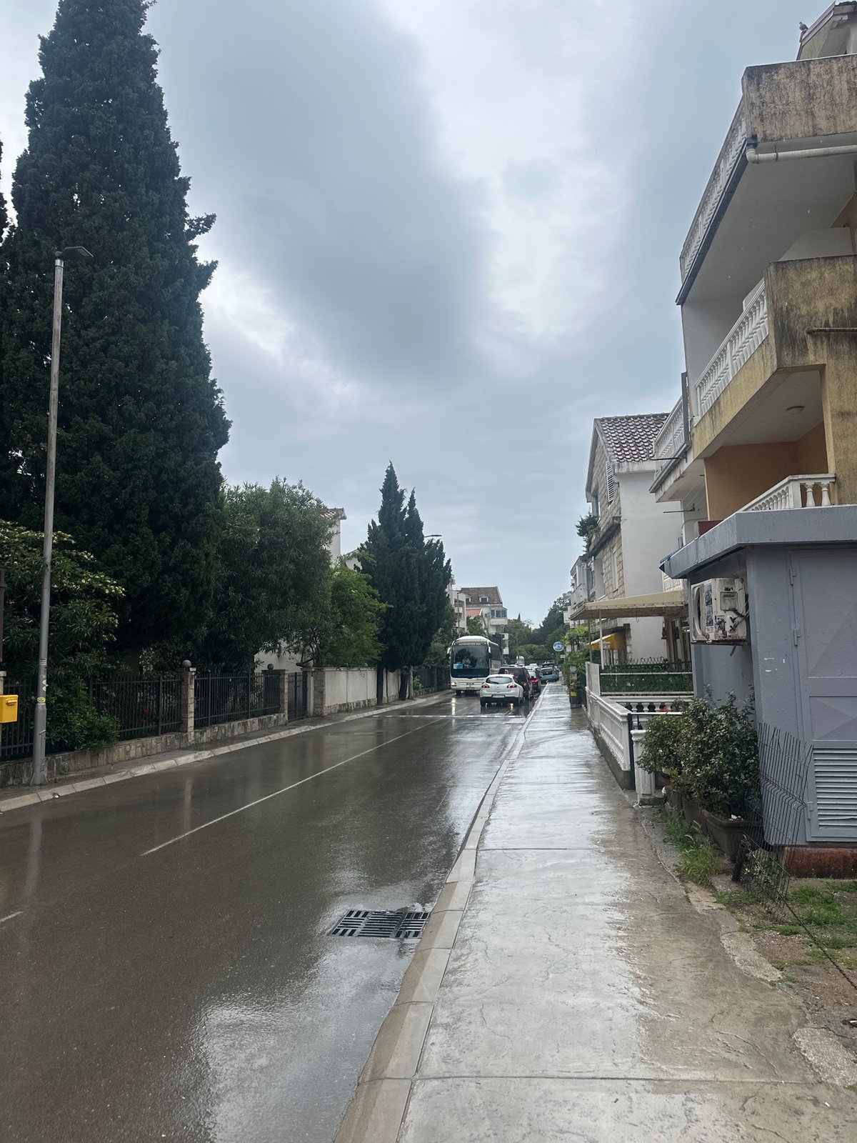 Man with umbrella navigates rainy Budva streets