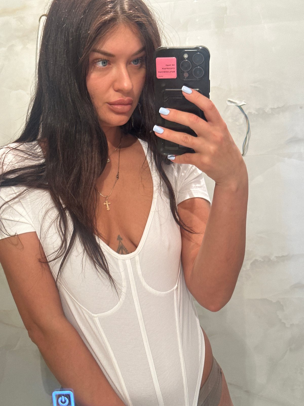 Woman takes mirror selfie with decorated smartphone in Moscow