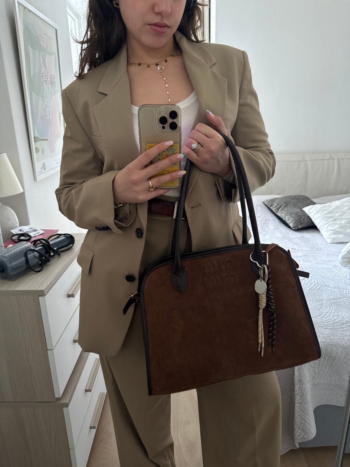 Woman takes mirror selfies in beige blazer, Milan morning
