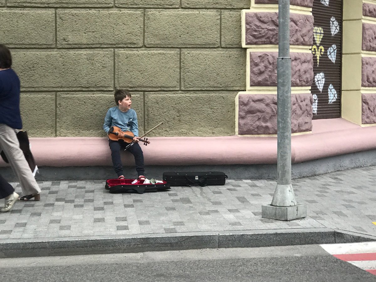 Street violin performance on pink ledge in Kharkiv