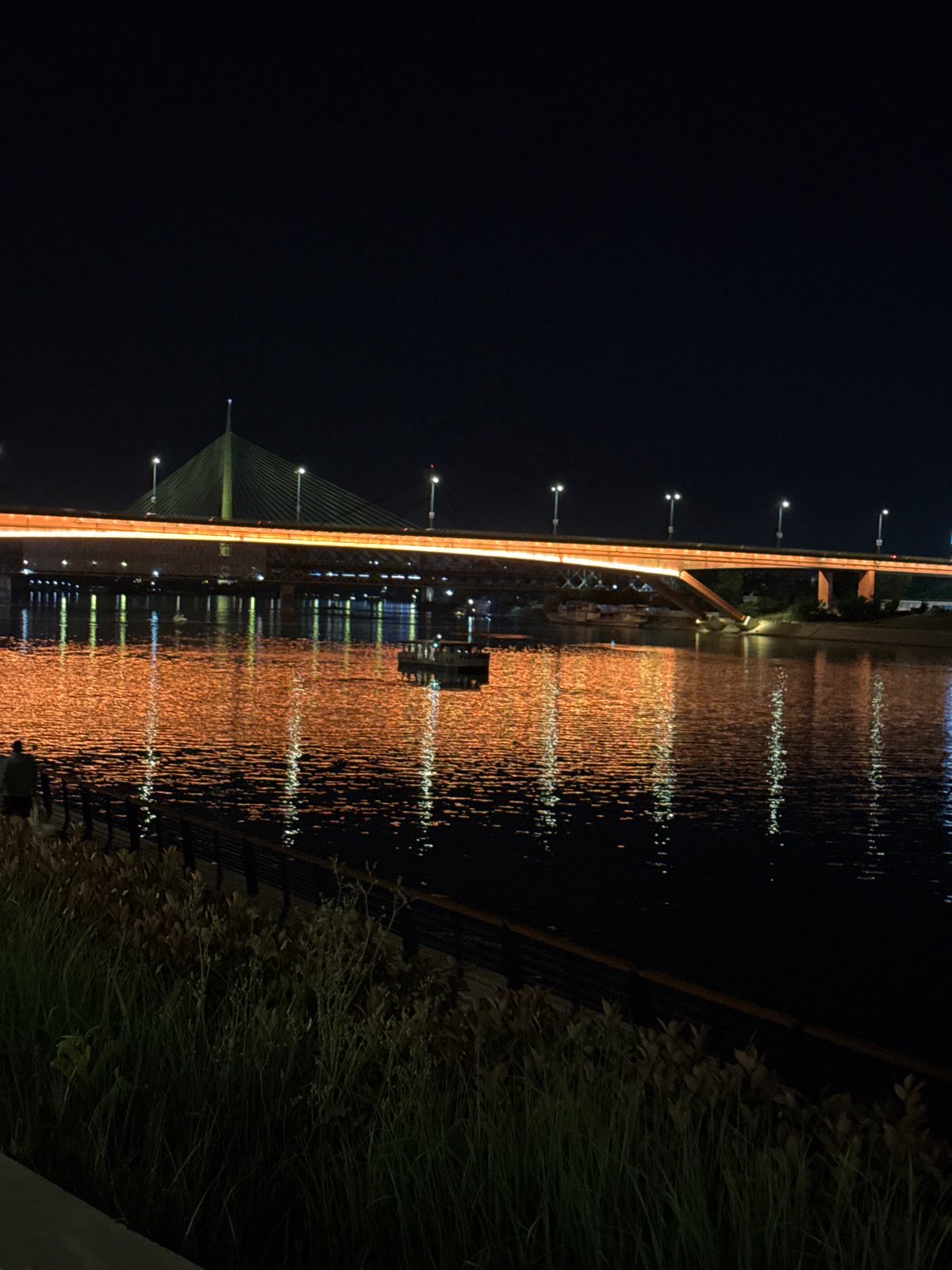 Nighttime urban lights captured across bridge and buildings