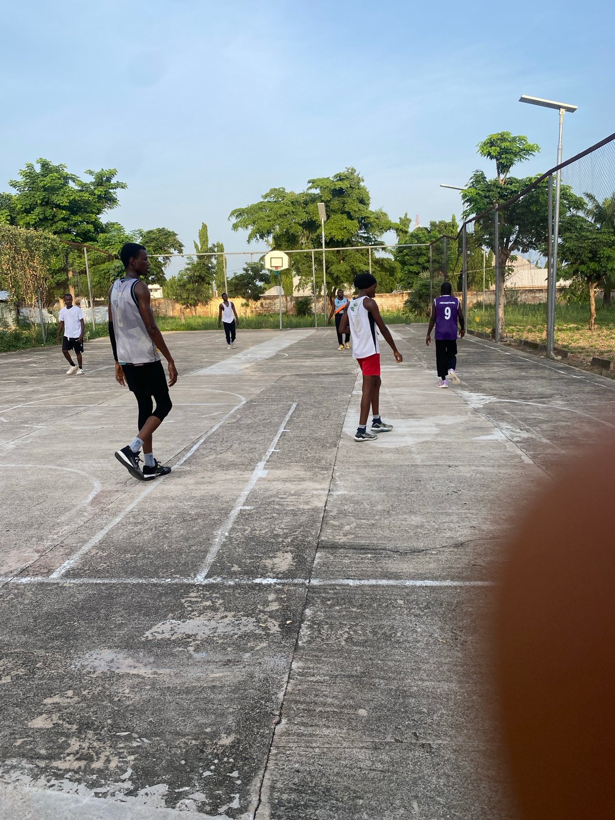 Outdoor basketball session on a concrete court in Jalingo, Nigeria