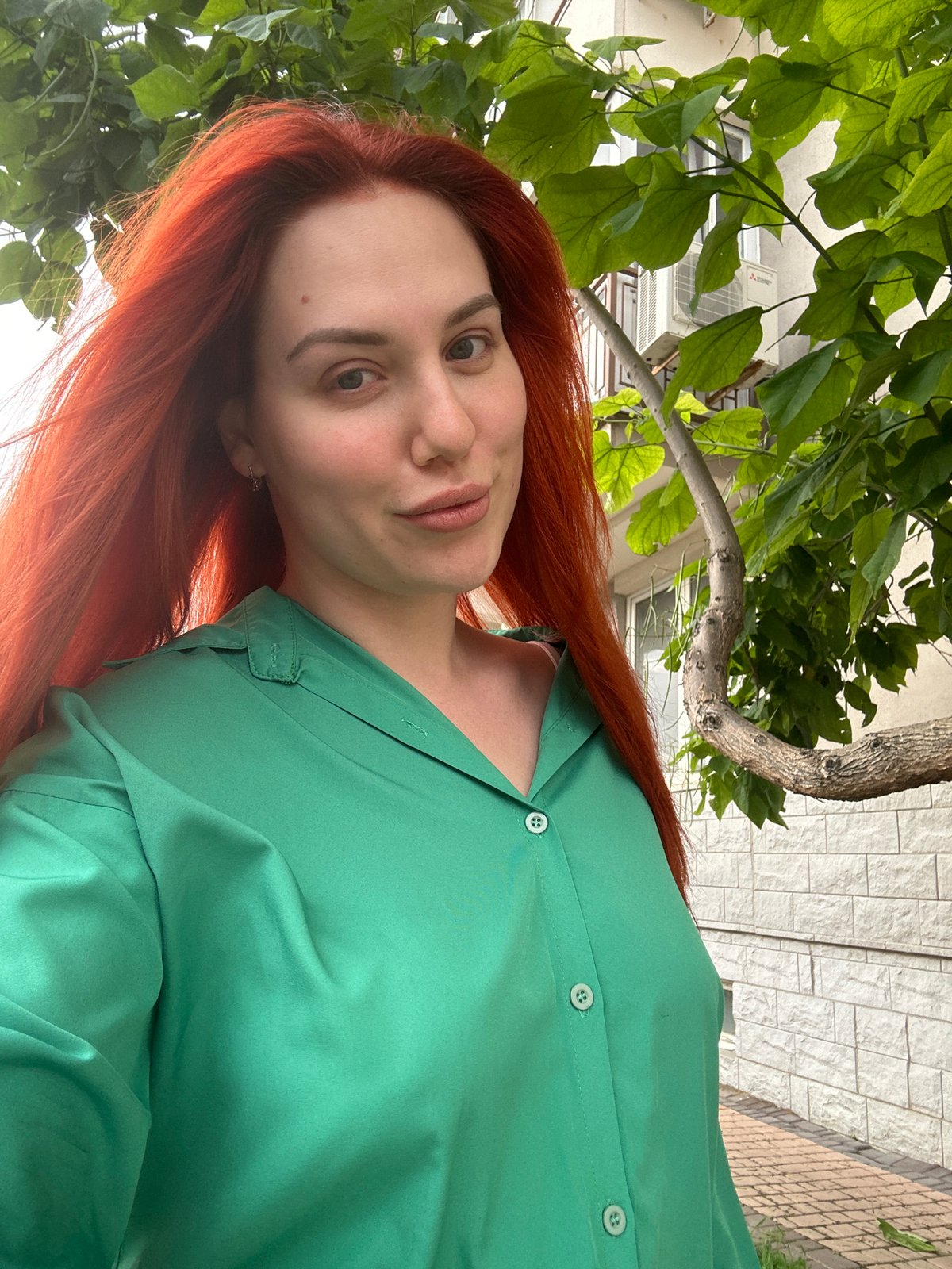 Selfie series on a sunny Odesa walkway, green outfit and red hair.