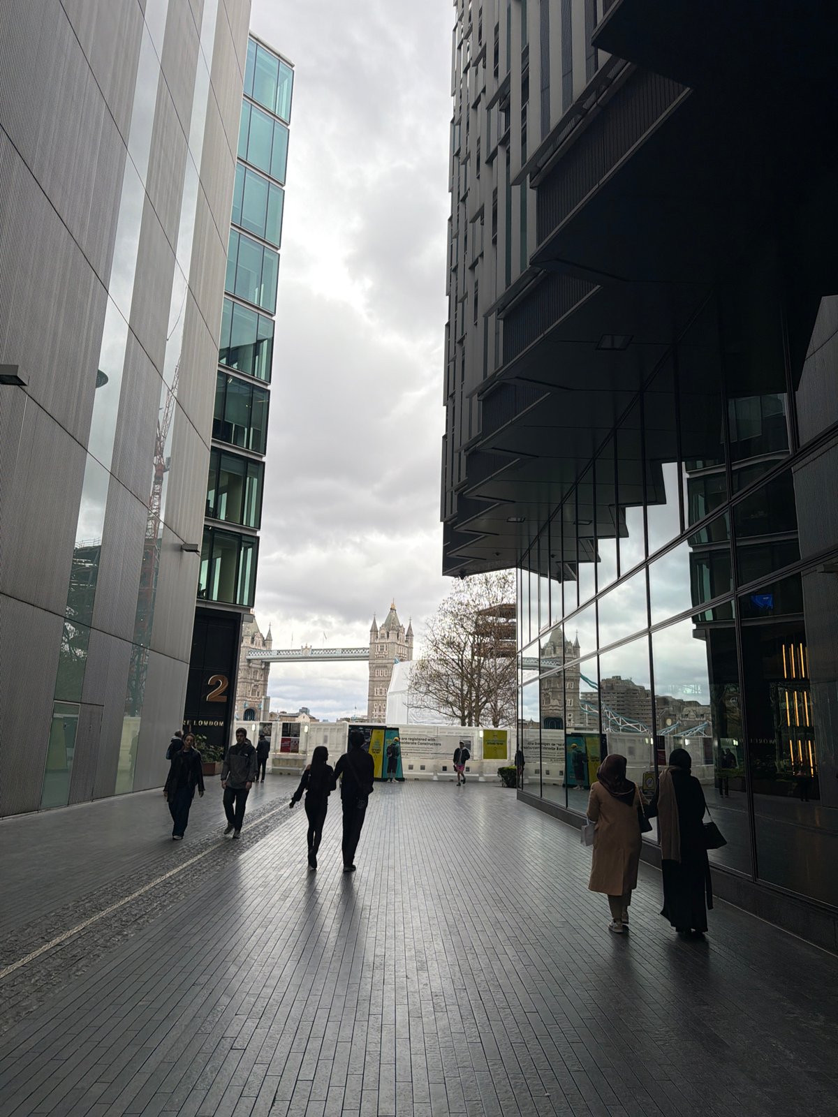 London street scene captures Tower Bridge between modern buildings