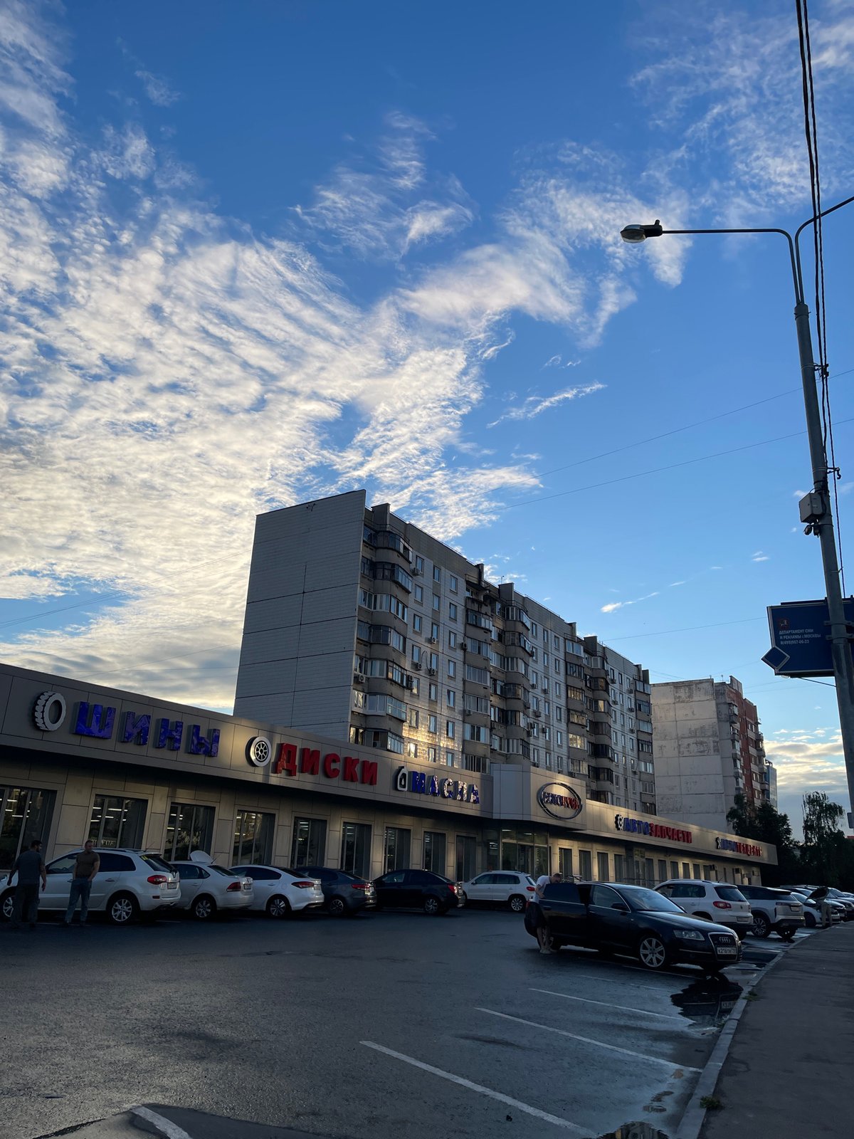 Moscow side street, auto shops and apartment blocks on a June afternoon