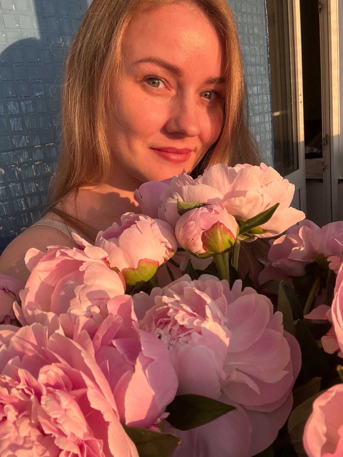 Woman with pink peonies photographed during Chaikovsky sunset session