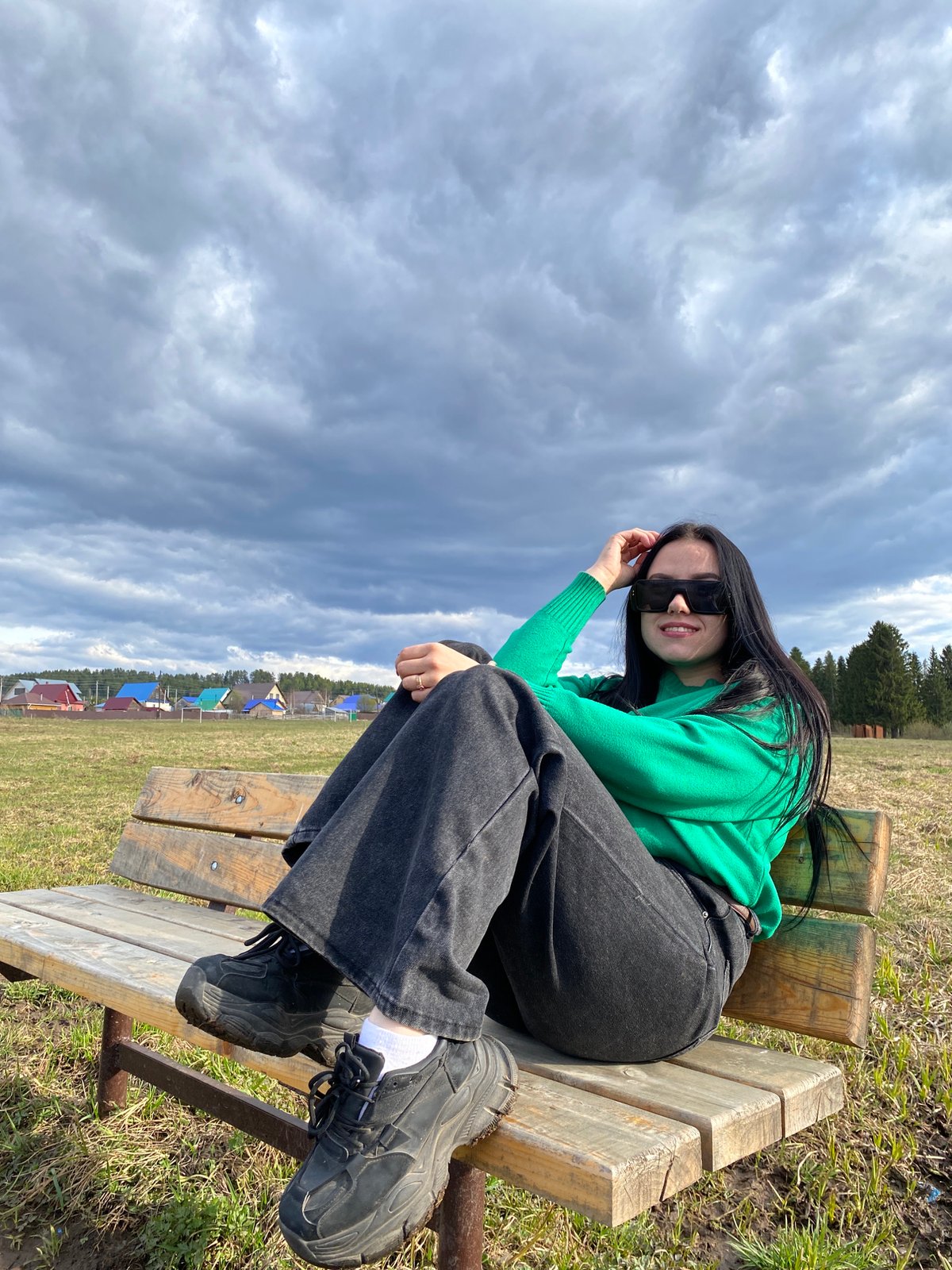Woman in green sweater photographed at multiple outdoor spots
