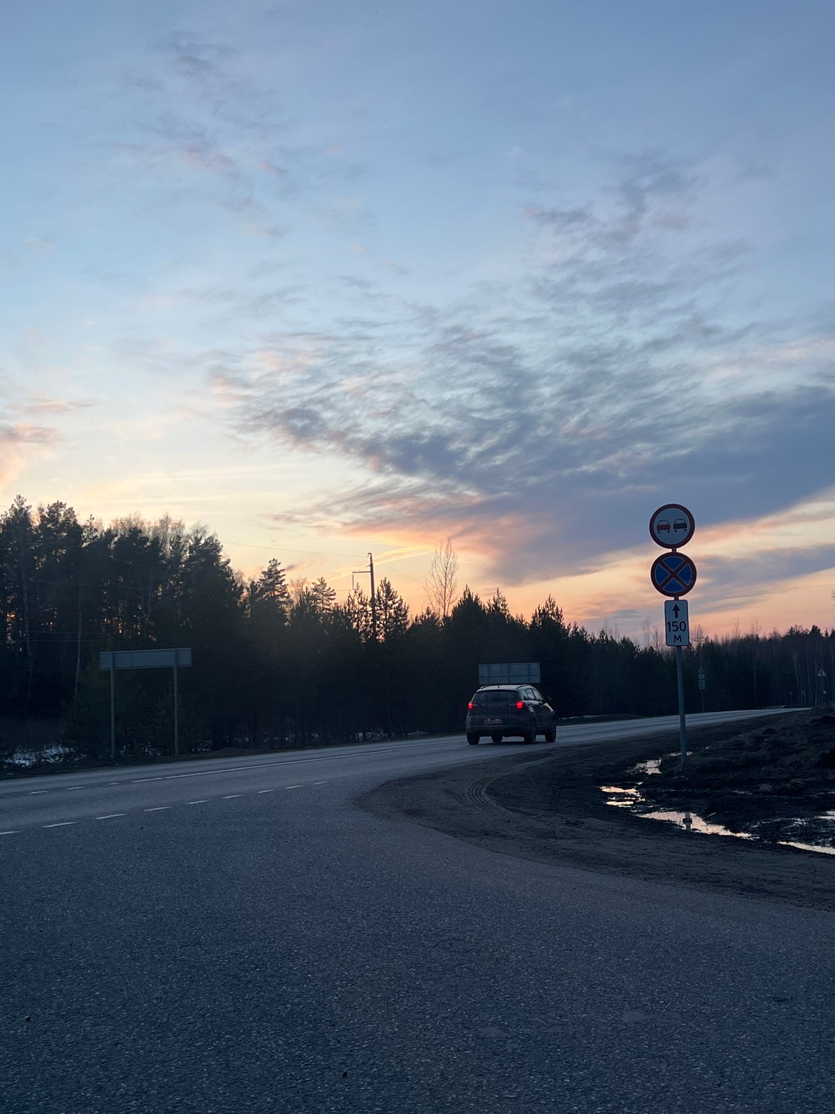 Silver SUV drives through forested road in Chaikovsky, Russia