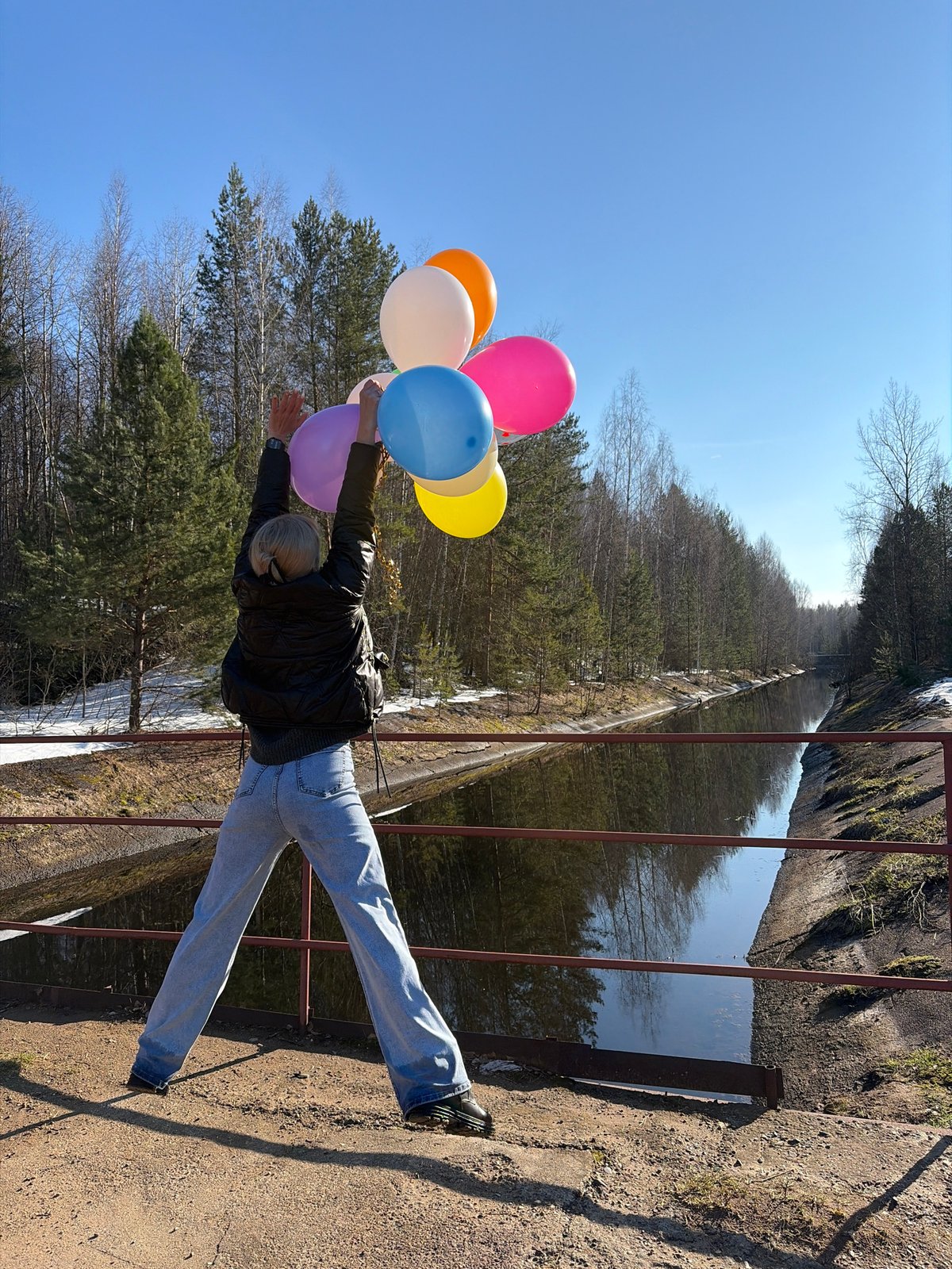 Woman poses with balloons, umbrella at Chernushka waterfall