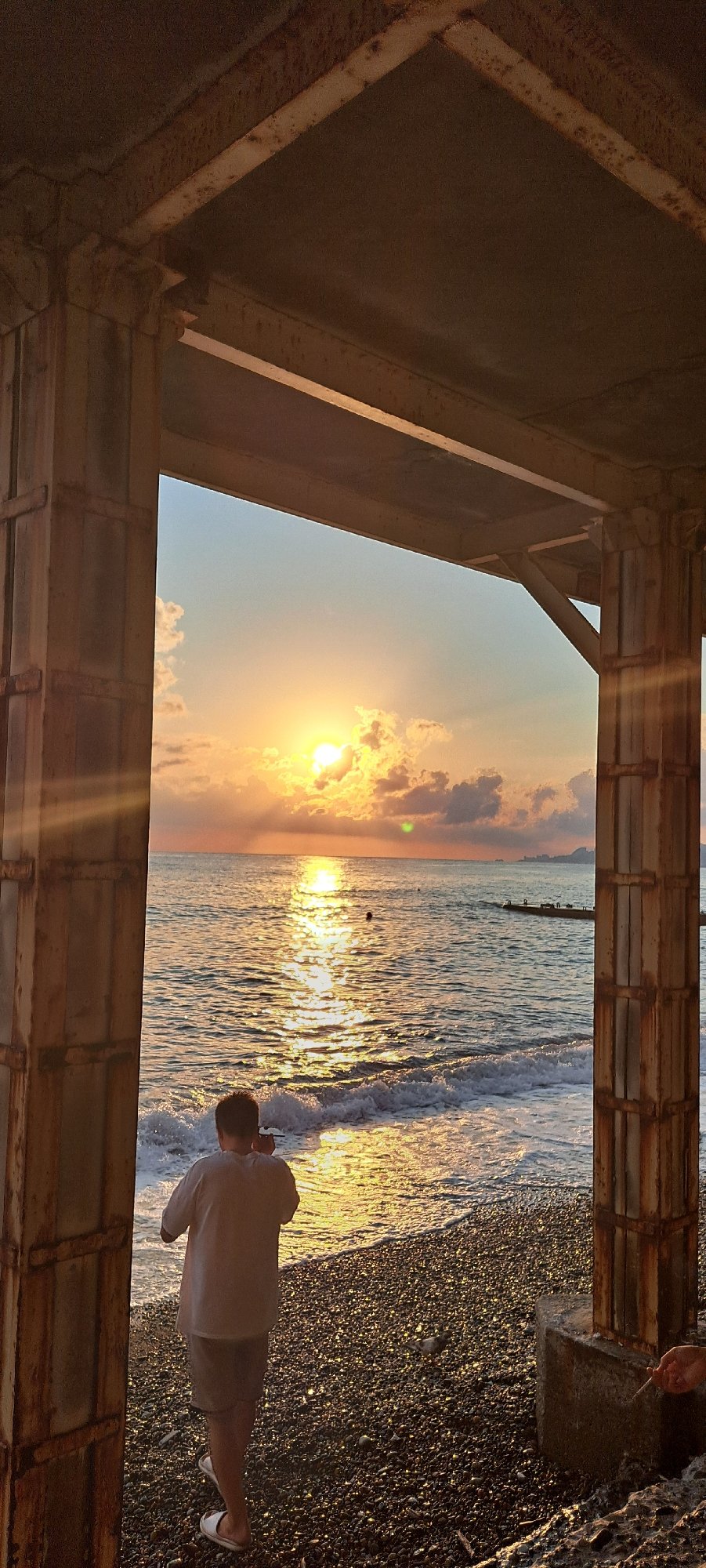 Sunset over the Black Sea, framed by rusted metal in Sochi