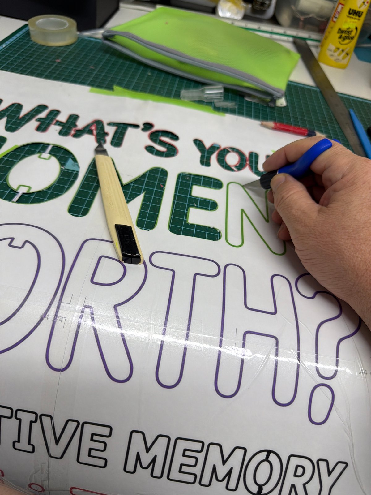 Craft worker cuts vinyl lettering in Even Yehuda workshop