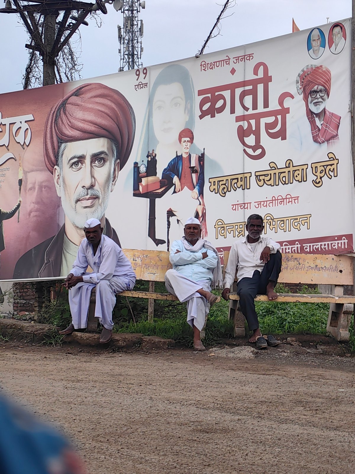 Busy rural road in Walsawangi with trucks, pedestrians, and local landmarks