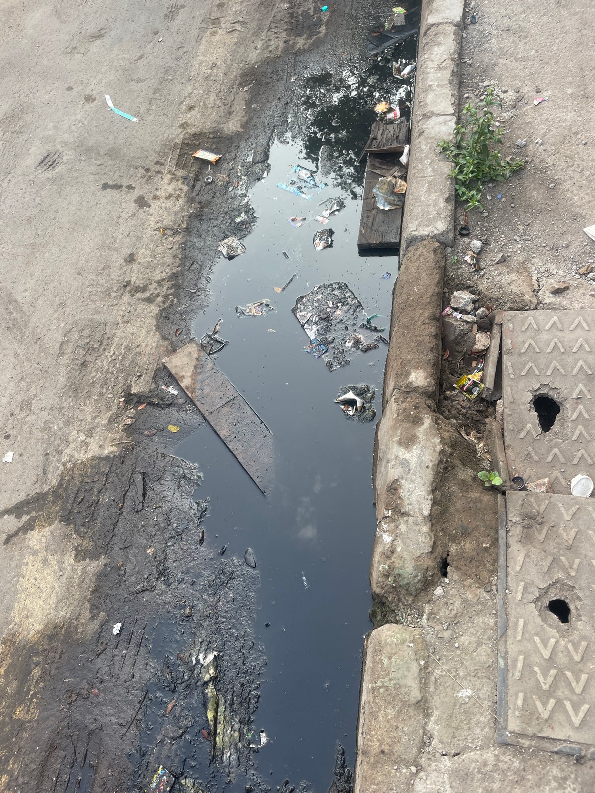 Urban scenes documented in Mumbai: drainage ditch, parked bus