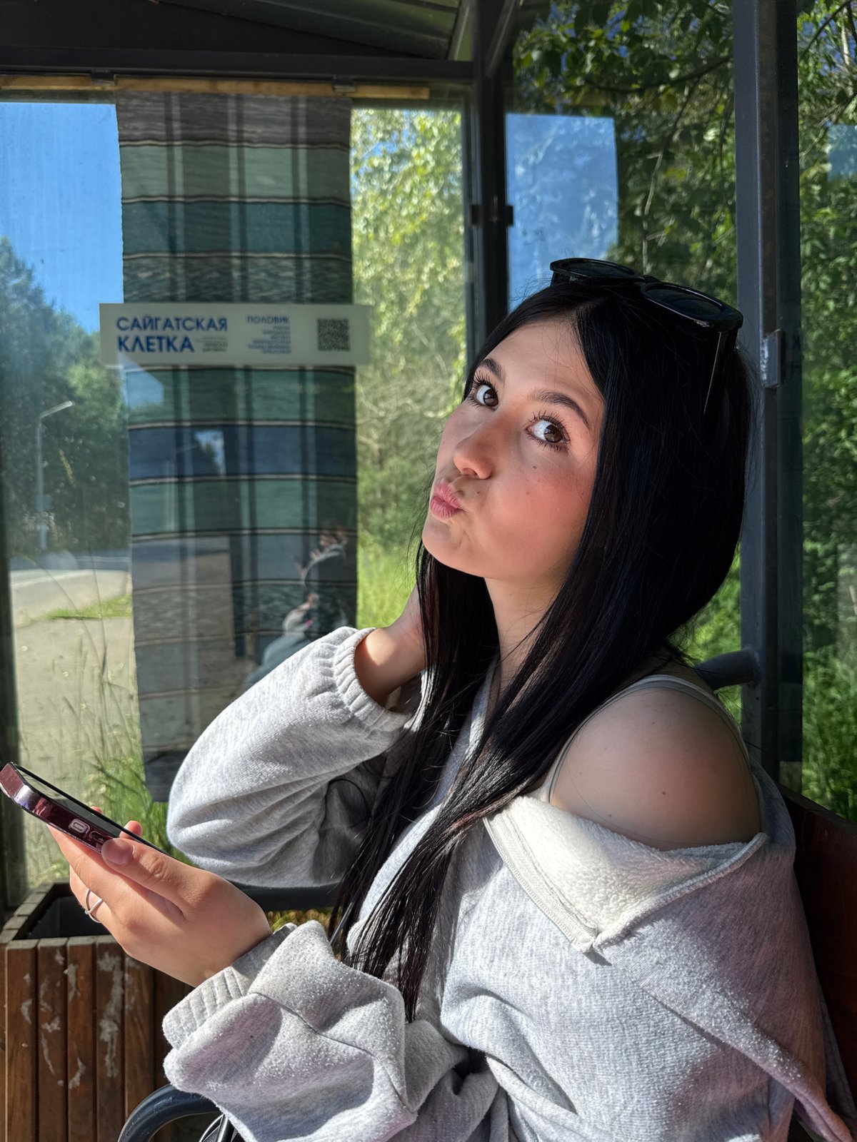 Friends passing time at a Chaikovsky bus stop, June morning