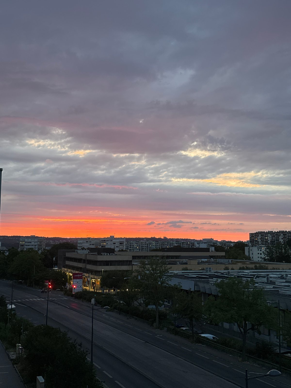 City skyline at dusk, dramatic sunset colors across the clouds.