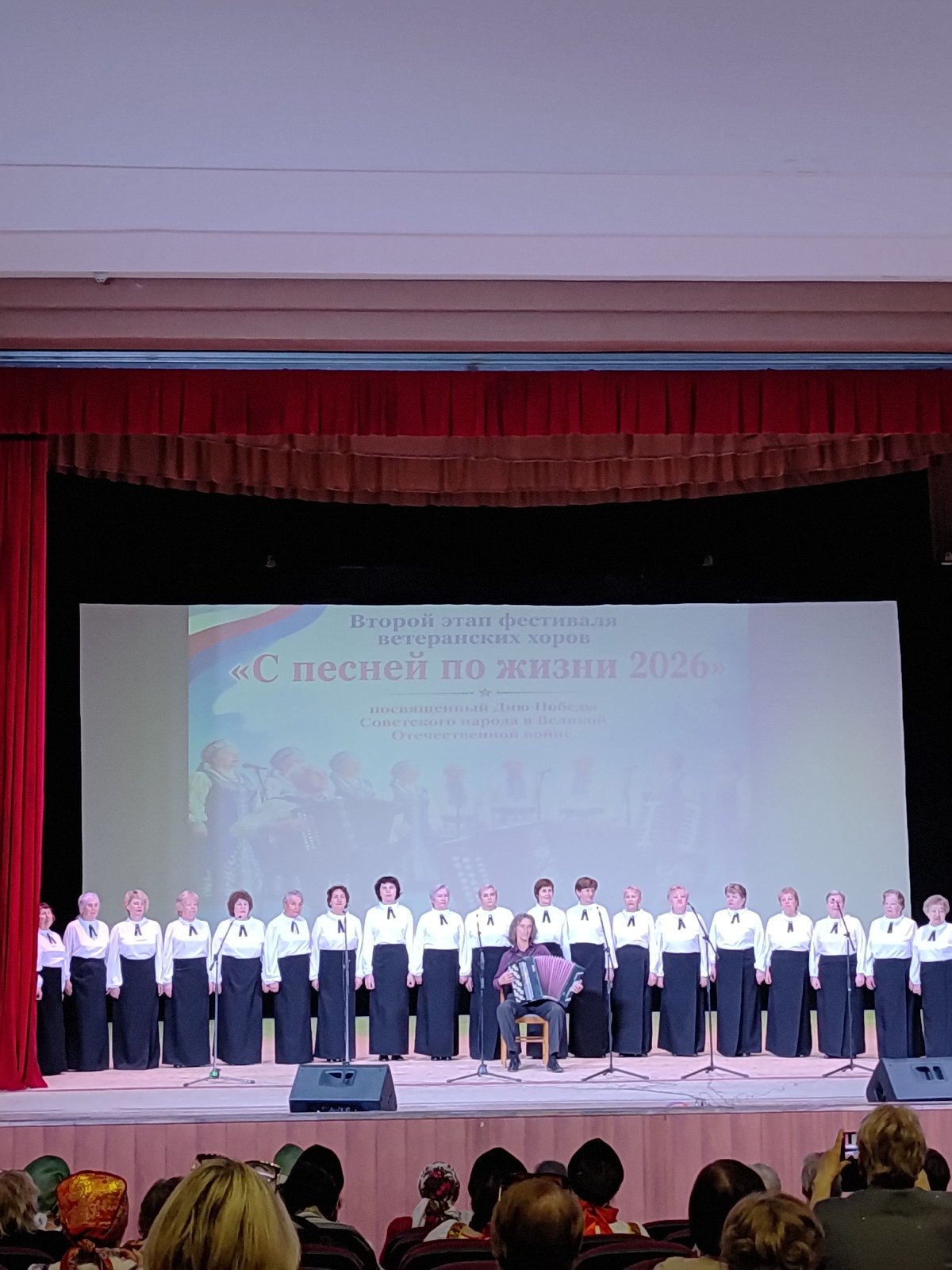 Elderly women's folk choir performs with accordion accompanist
