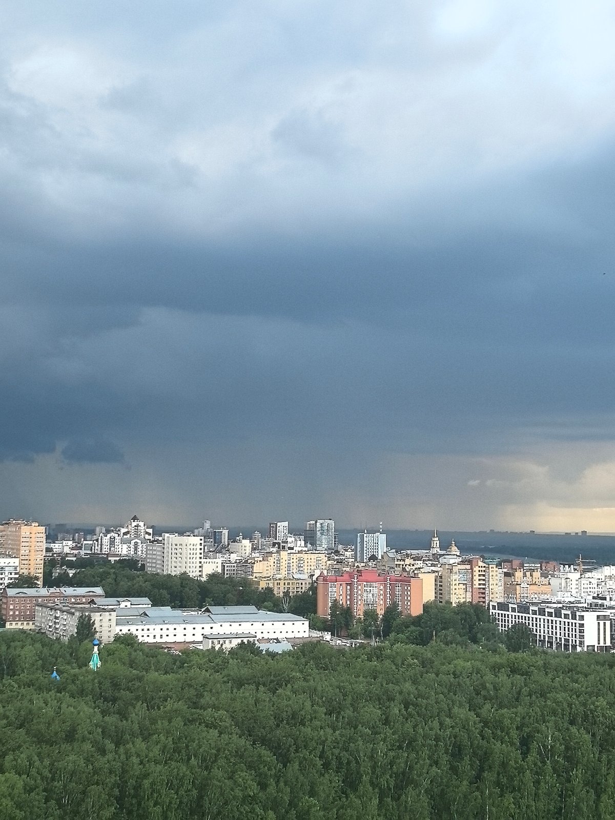 Storm clouds gather over Perm city and forest canopy