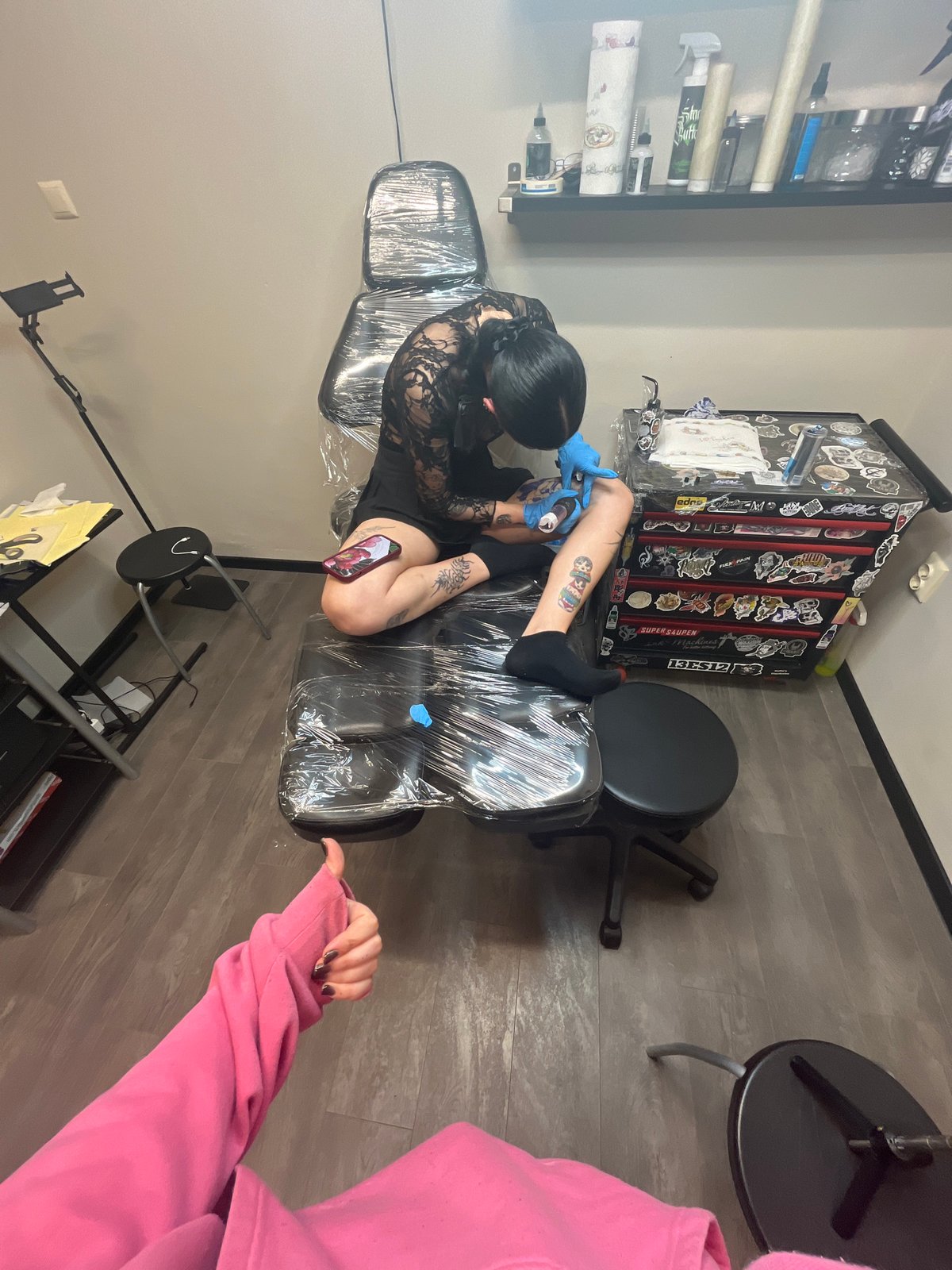 Tattoo artist works on client's leg in Sofia parlor