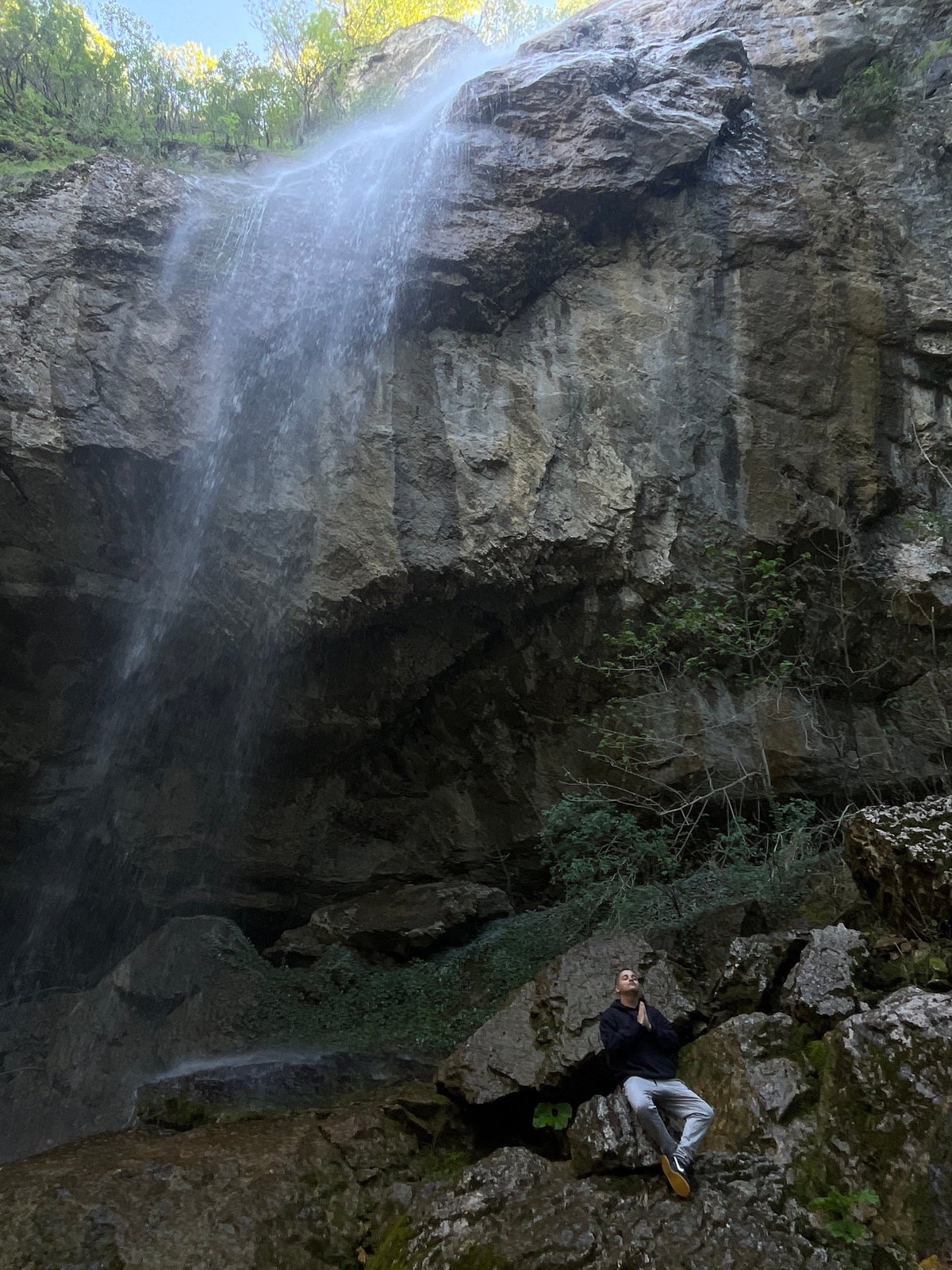 Visitors explore waterfall and caves near Veselinovo, Bulgaria