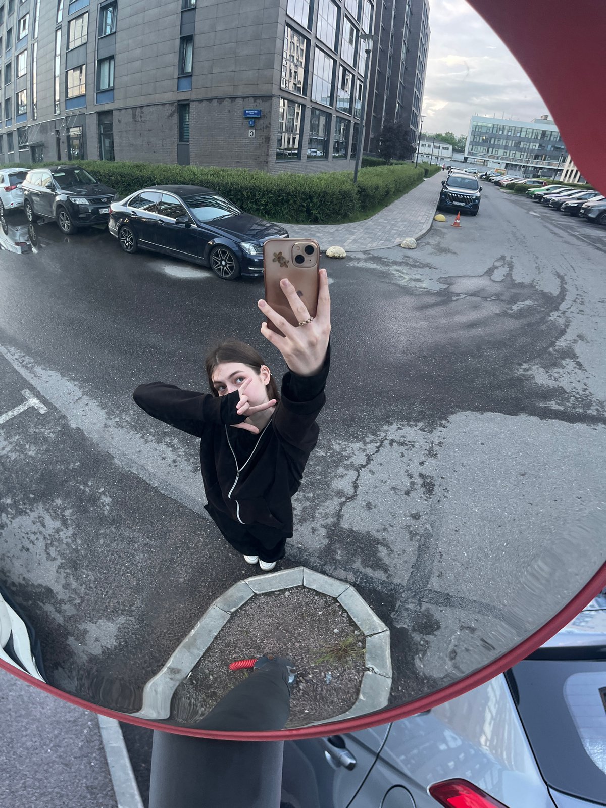 Woman takes distorted selfie in convex mirror on Russian street