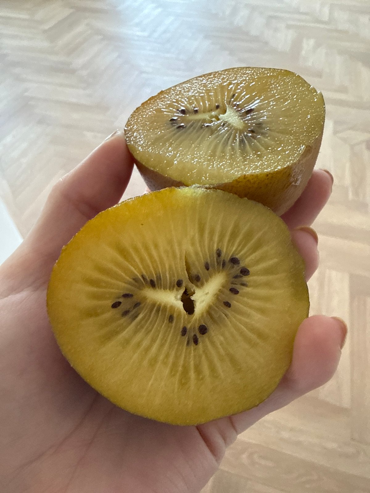 Golden kiwi fruit photographed in hand in Moscow