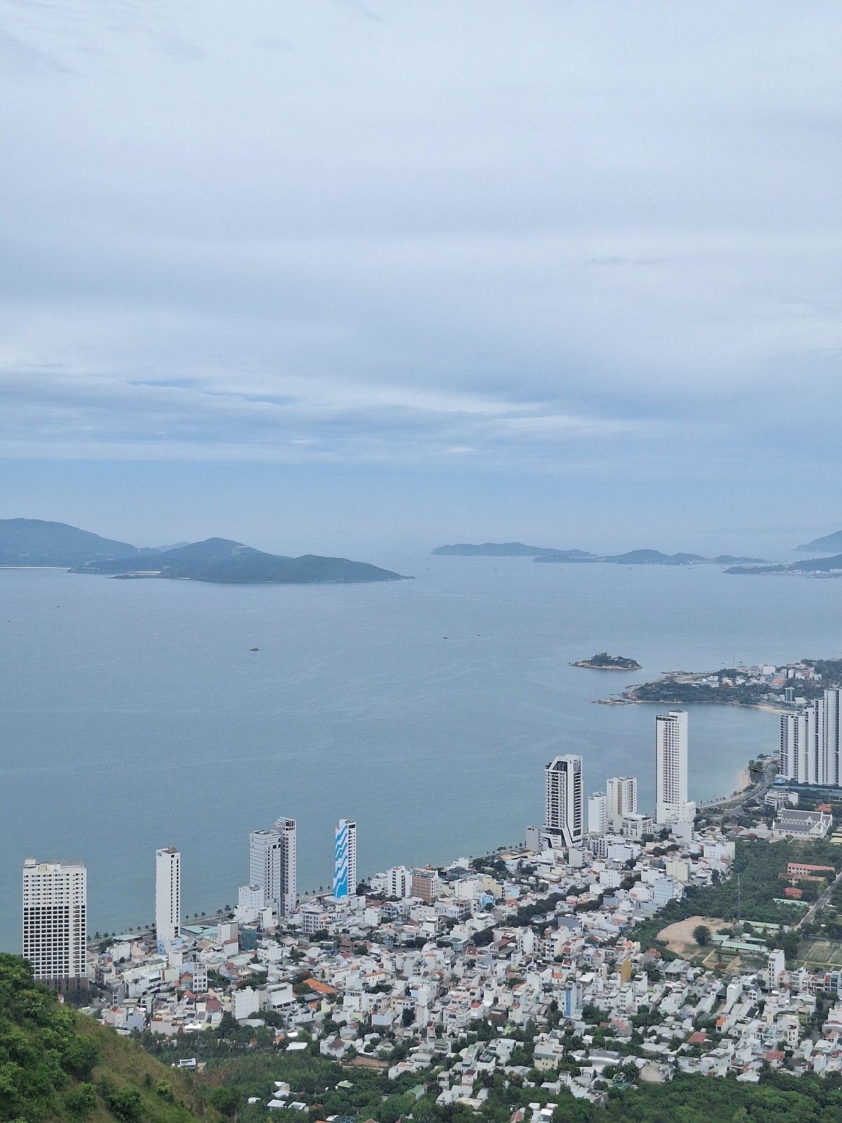 Hilltop panoramas over Nha Trang's coastal cityscape on an overcast morning