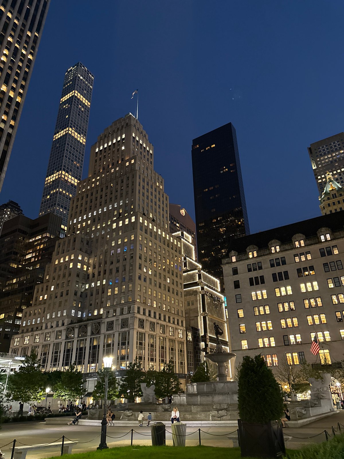 Midtown Manhattan glows at night from a public plaza