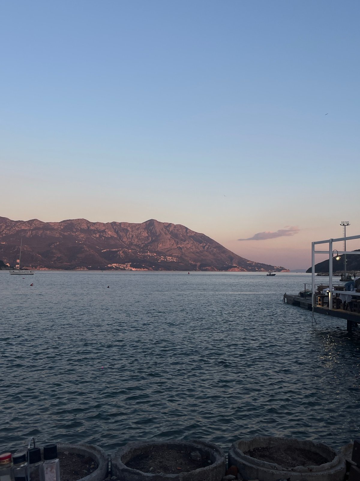 Seaside dining pier captures sunset colors in Budva, Montenegro