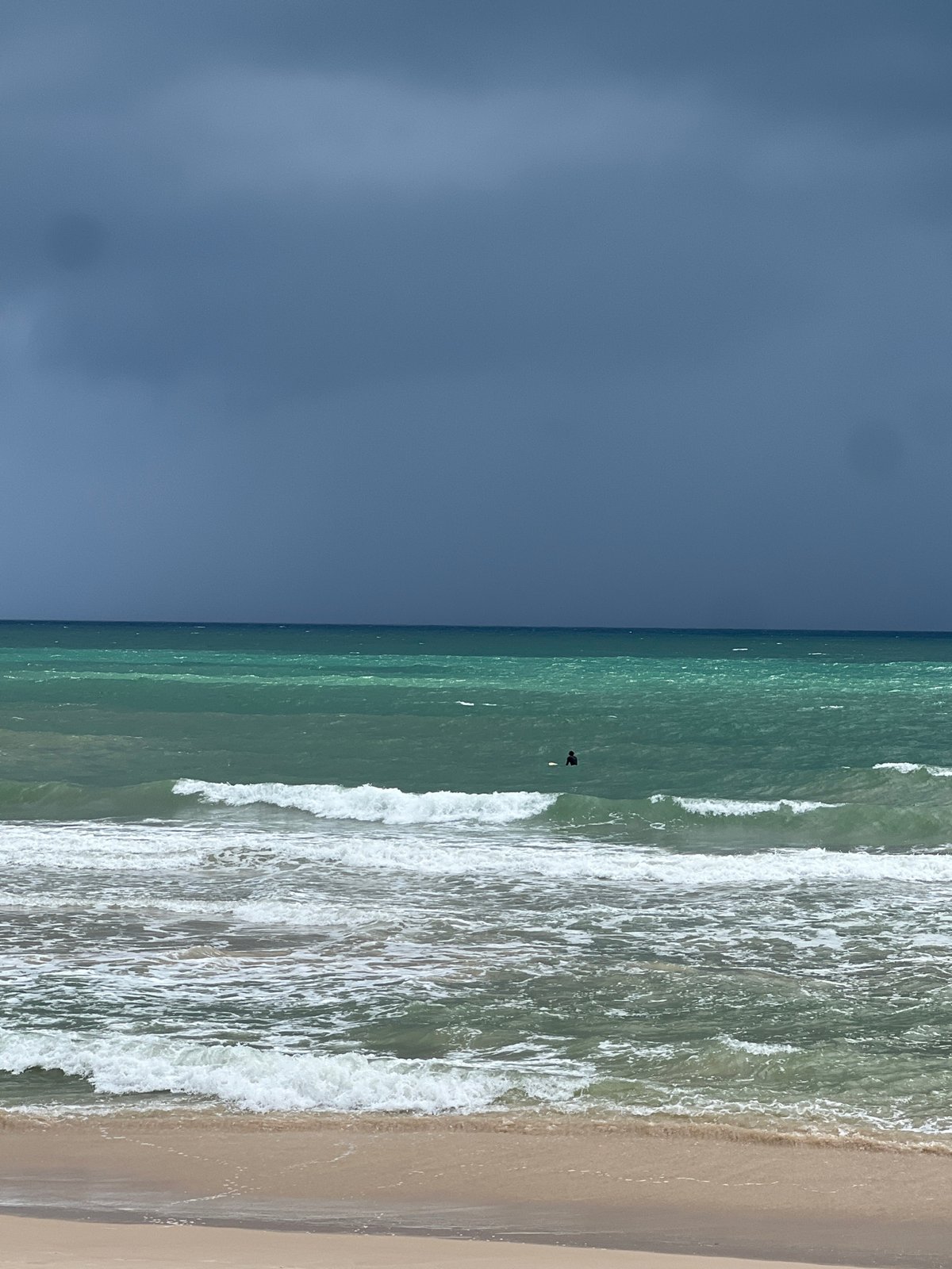 Surfing Choeng Thale's stormy break under dark skies