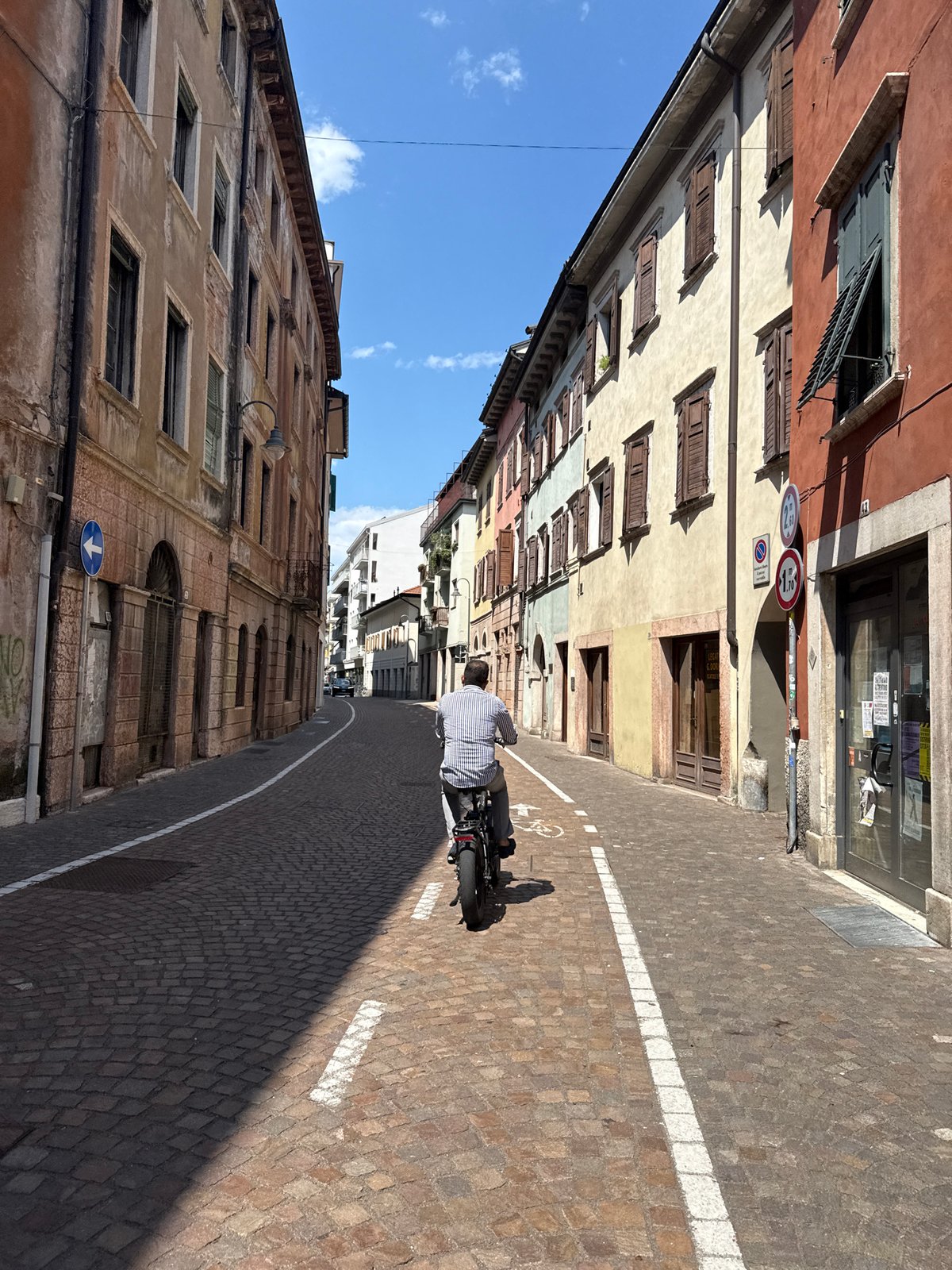 Cycling through Trento's old town streets on a summer afternoon