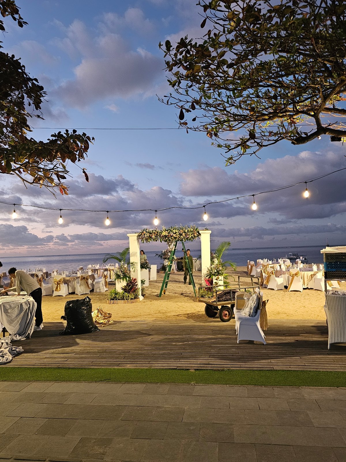 Beach wedding preparations documented at dusk in Denpasar