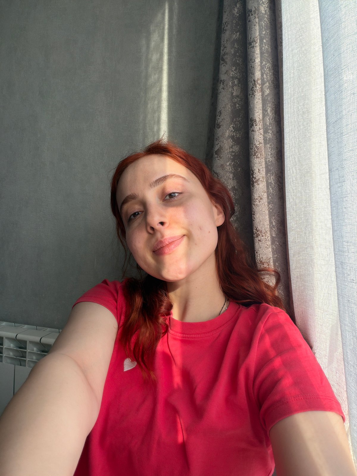 Woman takes selfies in red heart shirt in Tbilisi