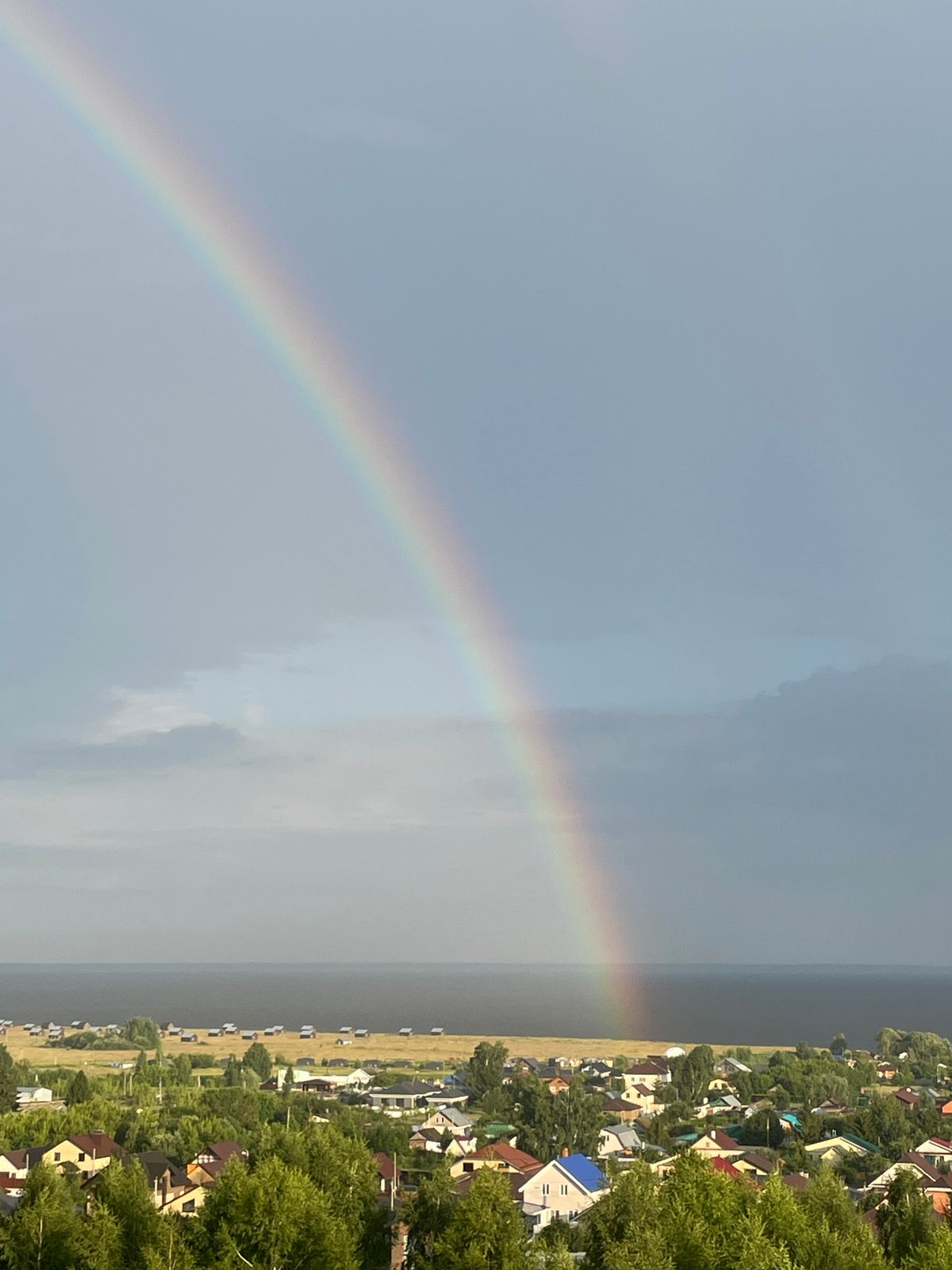 Rainbow over Laishevo's rooftops and waterfront after a storm
