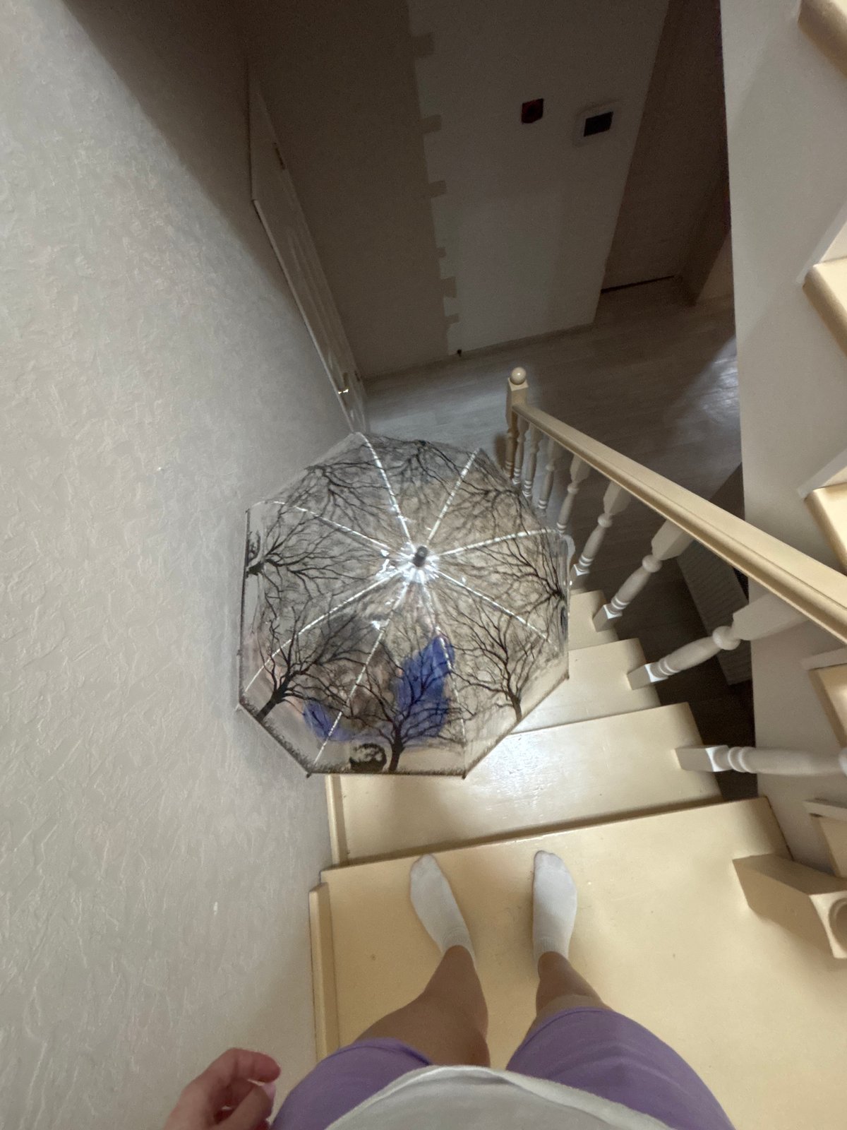 Child plays with decorative umbrella indoors in Russian home