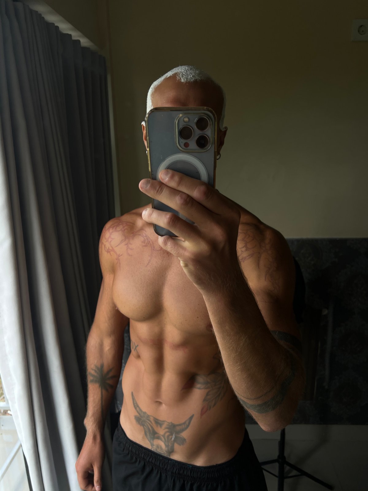 Mirror selfie session showing tattoos and physique in North Kuta