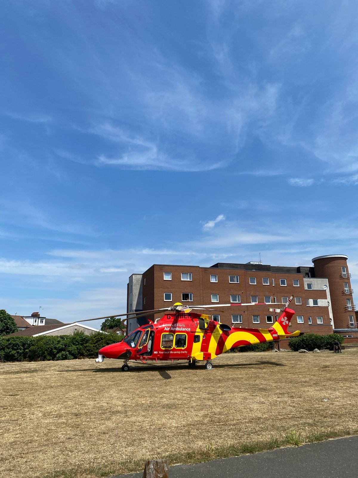 Essex & Herts Air Ambulance helicopter grounded on a grassy field