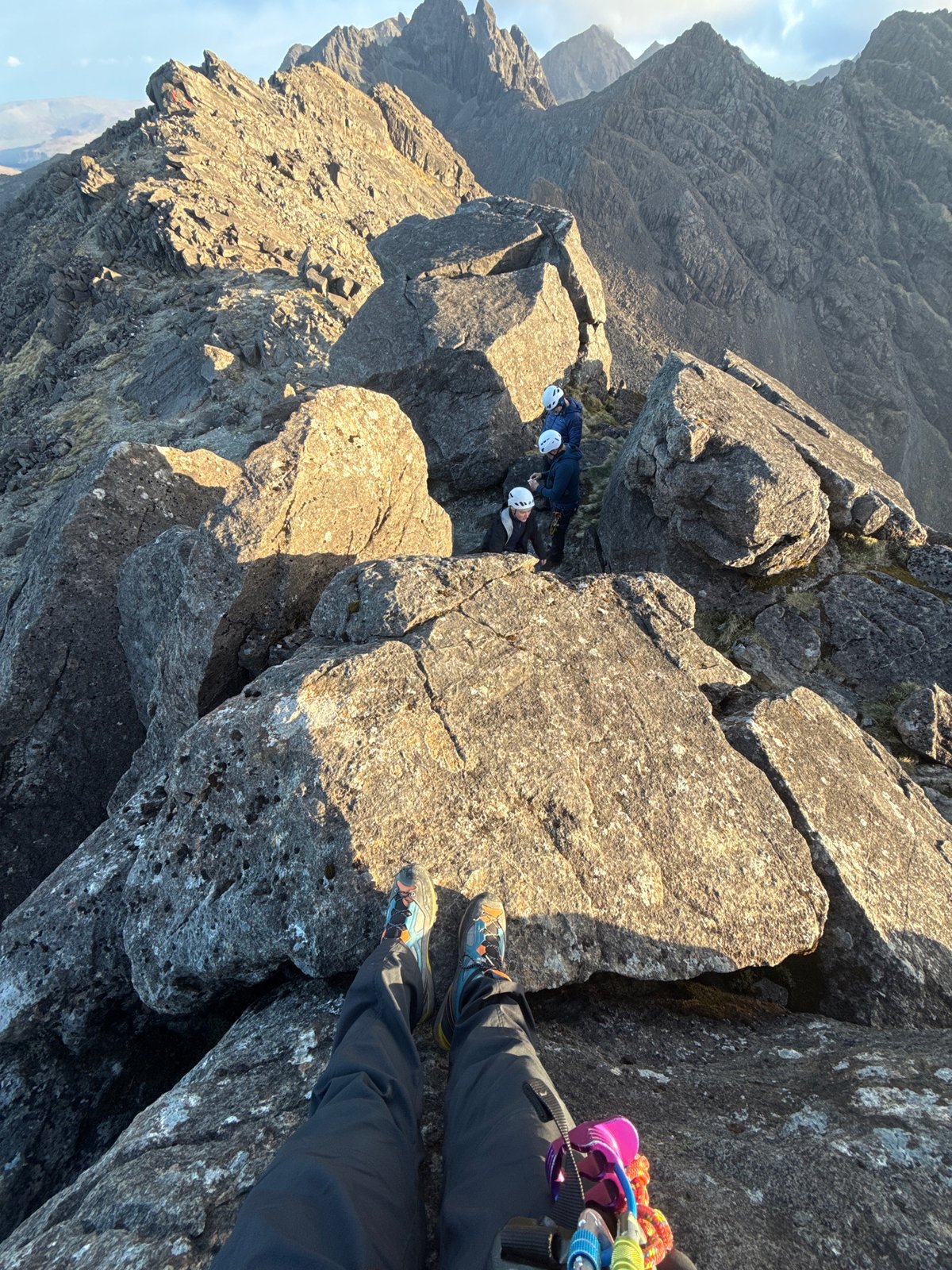 Three helmeted climbers spotted in rocky mountain terrain