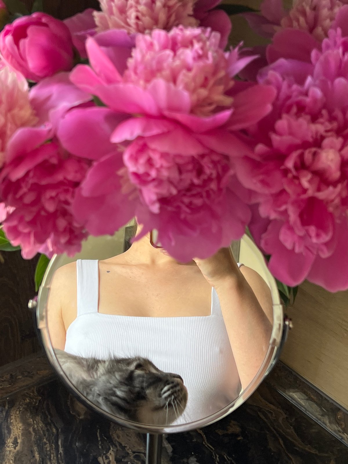 Woman documents quiet morning with cat and peonies in Ternopil