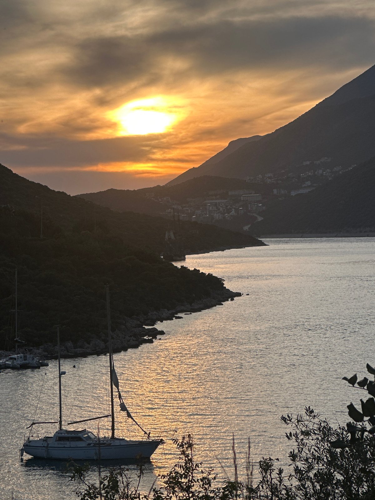 Sunset observed at Kaş harbor with sailboats and mountain backdrop