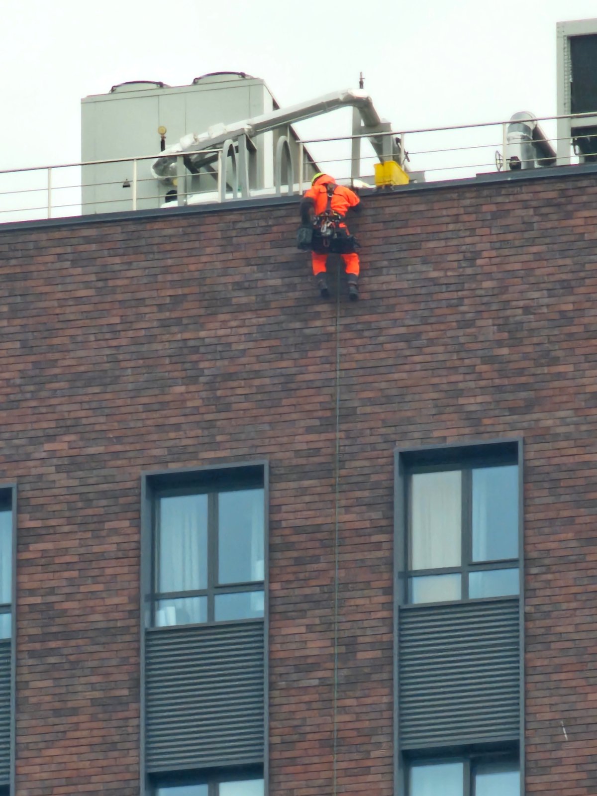 Worker rappels down building facade in Khimki, Russia