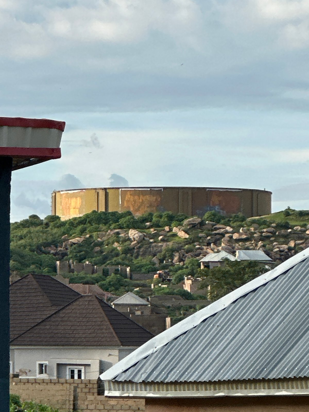 Hillside residential area in Jos, Nigeria, with water tank landmark