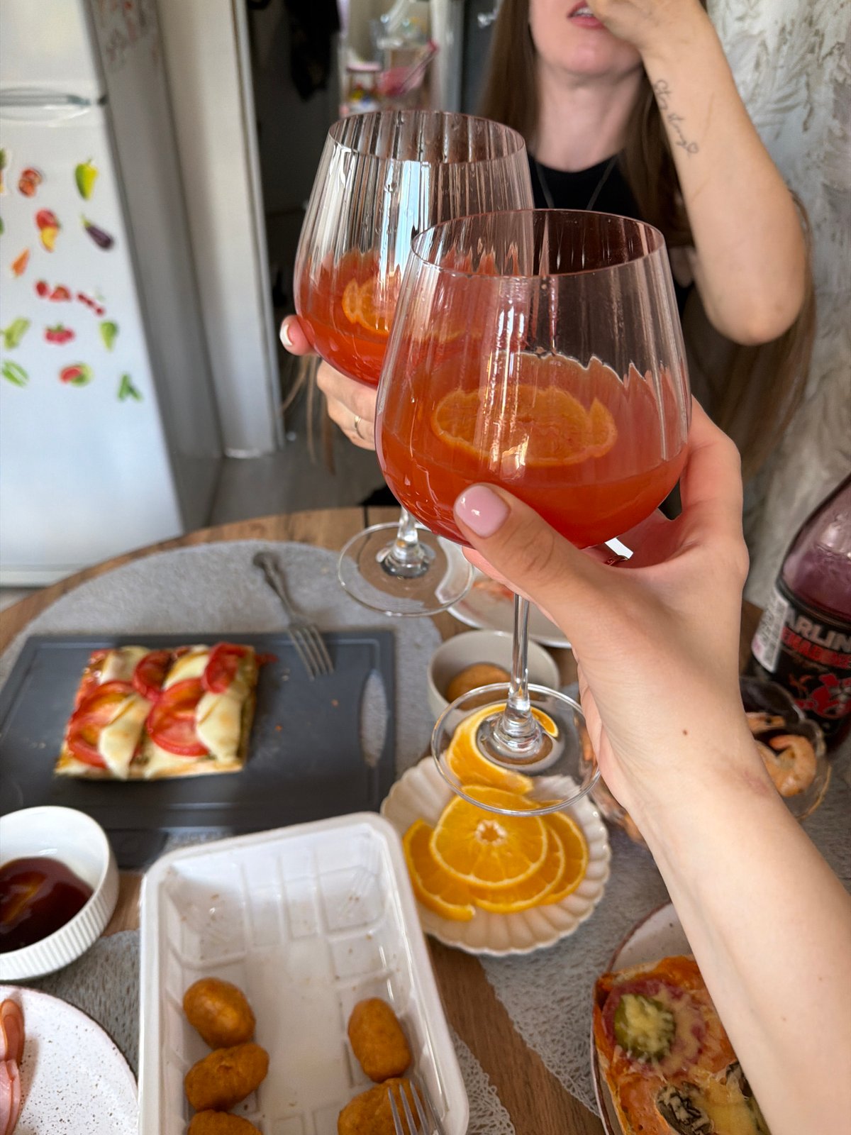 Women toast with drinks during home gathering in Reshetnikovo