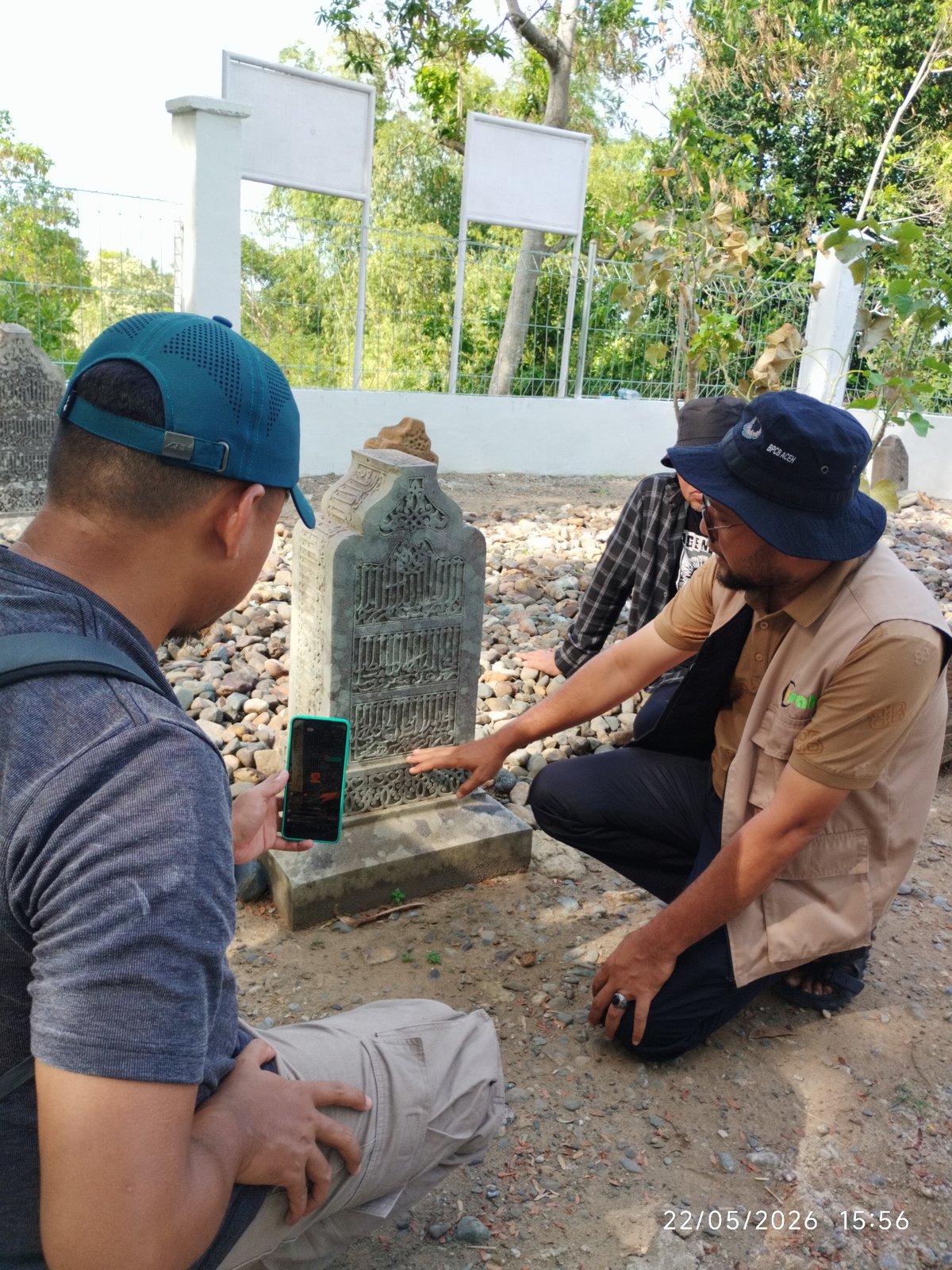 Men photograph Arabic headstone in Ulee Tutue, Indonesia