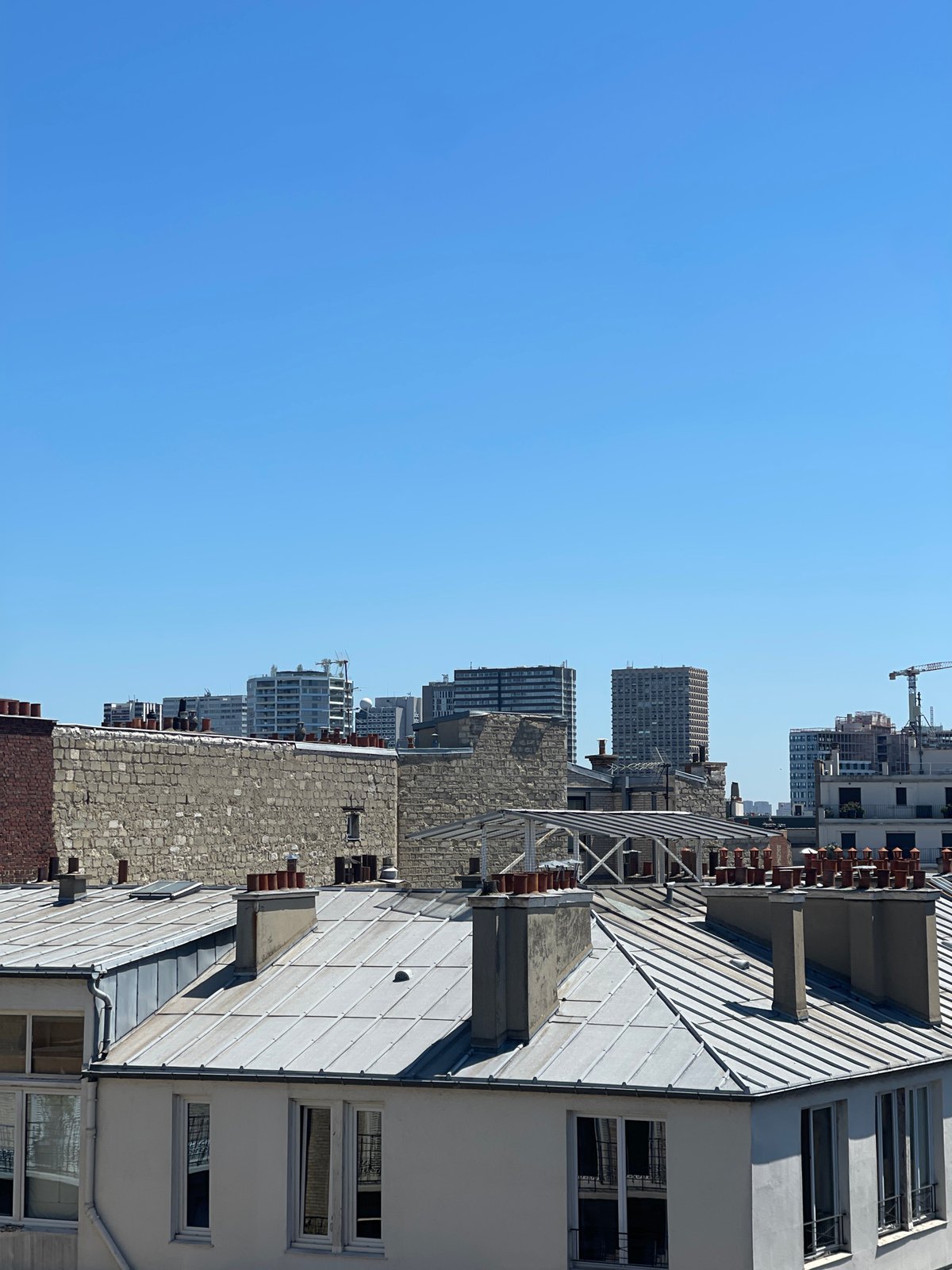 Paris rooftops under a clear blue sky