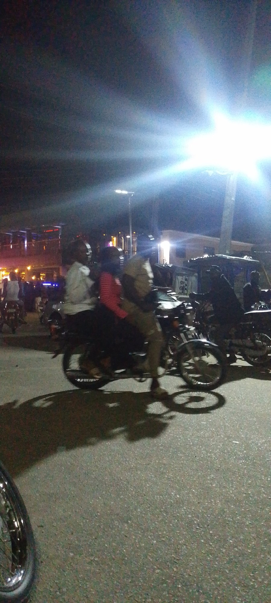 Nighttime street scene with damaged car in Lokoja, Nigeria