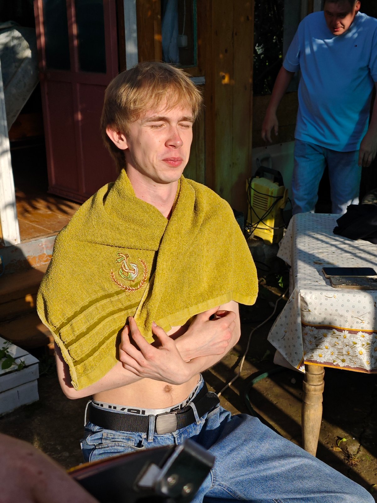 Backyard hangout in rural Russia, centered on an outdoor head shave