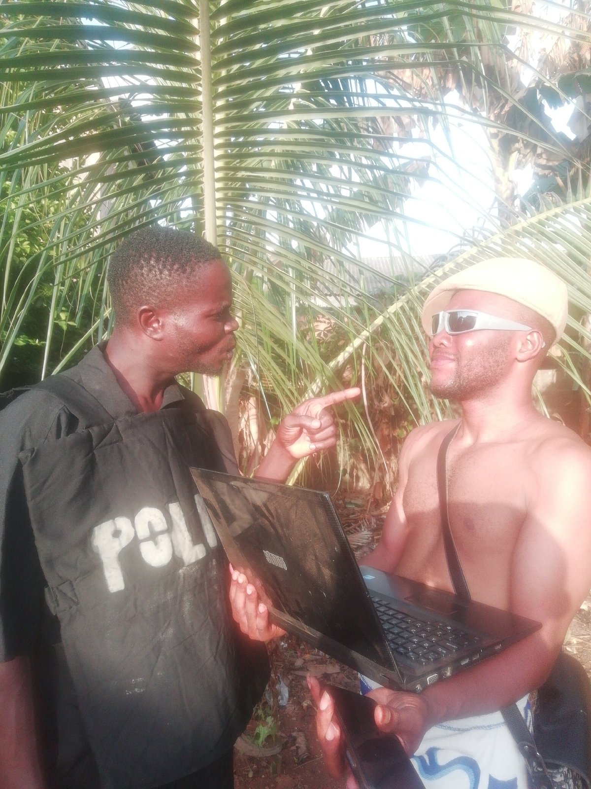 Man with laptop documented in tropical outdoor setting
