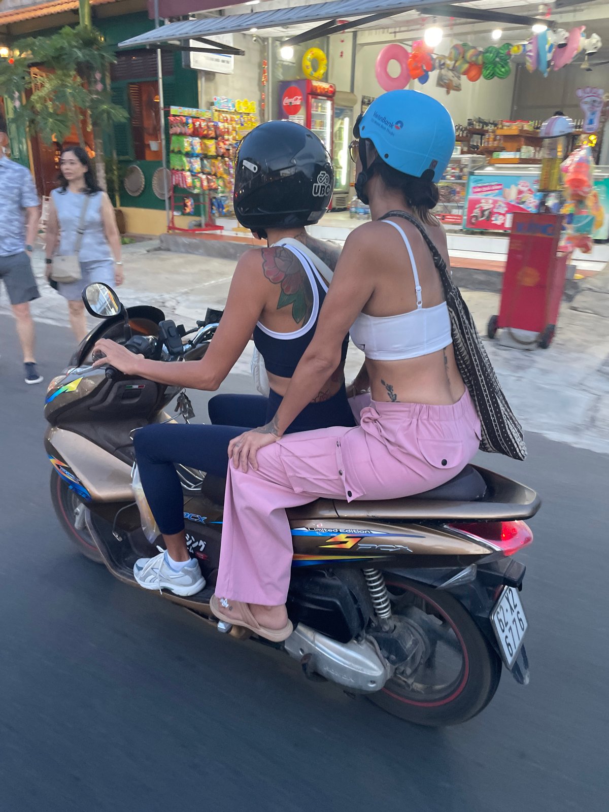 Motorbike riders cruising Phu Thuy Ward's palm-lined streets